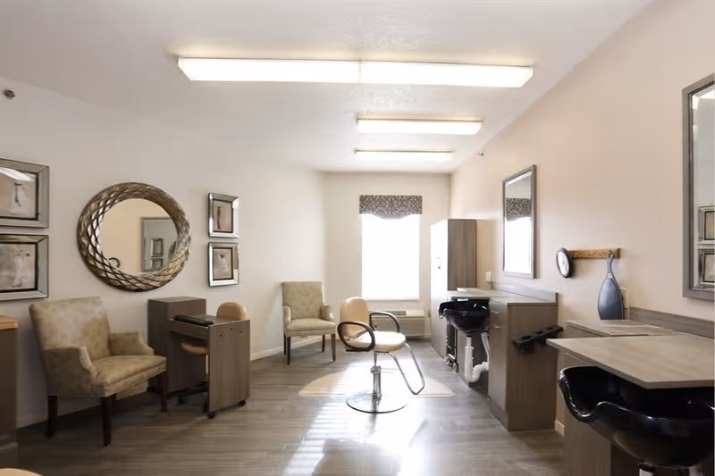 Bright salon-style interior with styling chairs, wash basins, mirrors and guest seating.