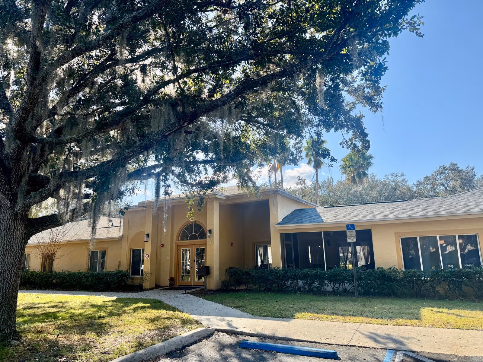 A senior living facility with a welcoming entrance surrounded by trees.