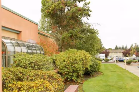 Exterior view of Rainier Rehabilitation building with orange walls, glass entry, and landscaping.