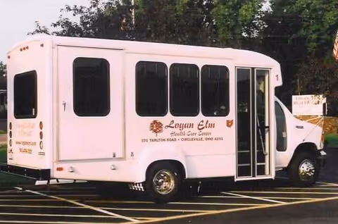 White Logan Elm Health Care Center shuttle bus parked in a lot