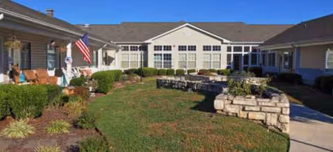 Brookdale Kingsport exterior: a single-story senior living building with a landscaped courtyard and people at entrance.