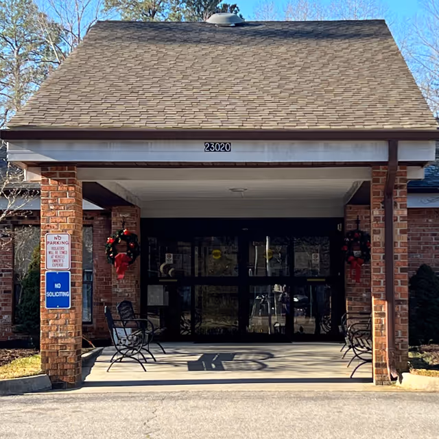 Front entrance of Courtland Health & Rehabilitation Center with brick pillars and glass doors.