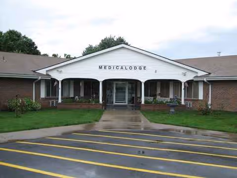 Front view of Medicalodges Douglass with a white covered entrance and parking.