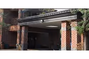 Covered brick entrance/portico with brick columns and a drop-off area in front of a health center.