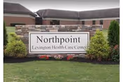 Sign reading Northpoint Lexington Health Care Center in front of a brick building with shrubs