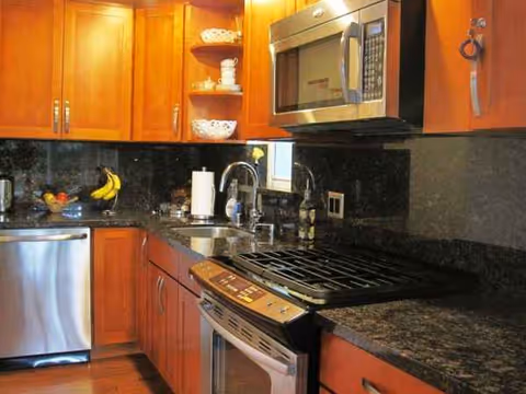 Cozy Glen kitchen with wooden cabinets, granite counters, and stainless appliances.