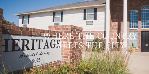 Heritage Assisted Living building exterior with brick sign and landscaping.