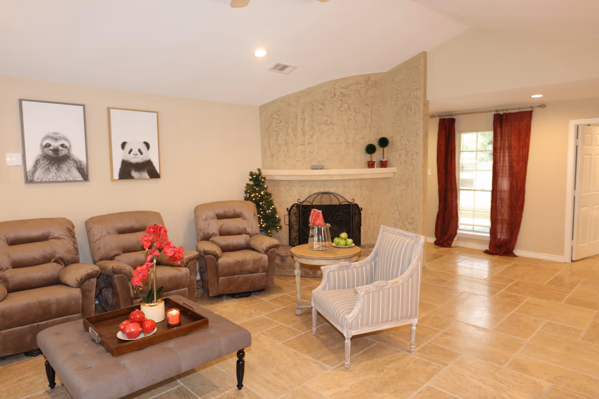 Cozy living room with three brown recliners, a striped armchair, ottoman coffee table, fireplace and wall art of a sloth and a panda.