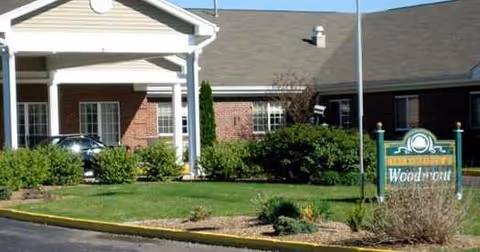 Exterior view of Woodmont Health Campus entrance with lawn, shrubs, and a front sign.