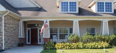 Exterior view of Brookdale Westerville showing a covered entrance, flag, and landscaped front yard.