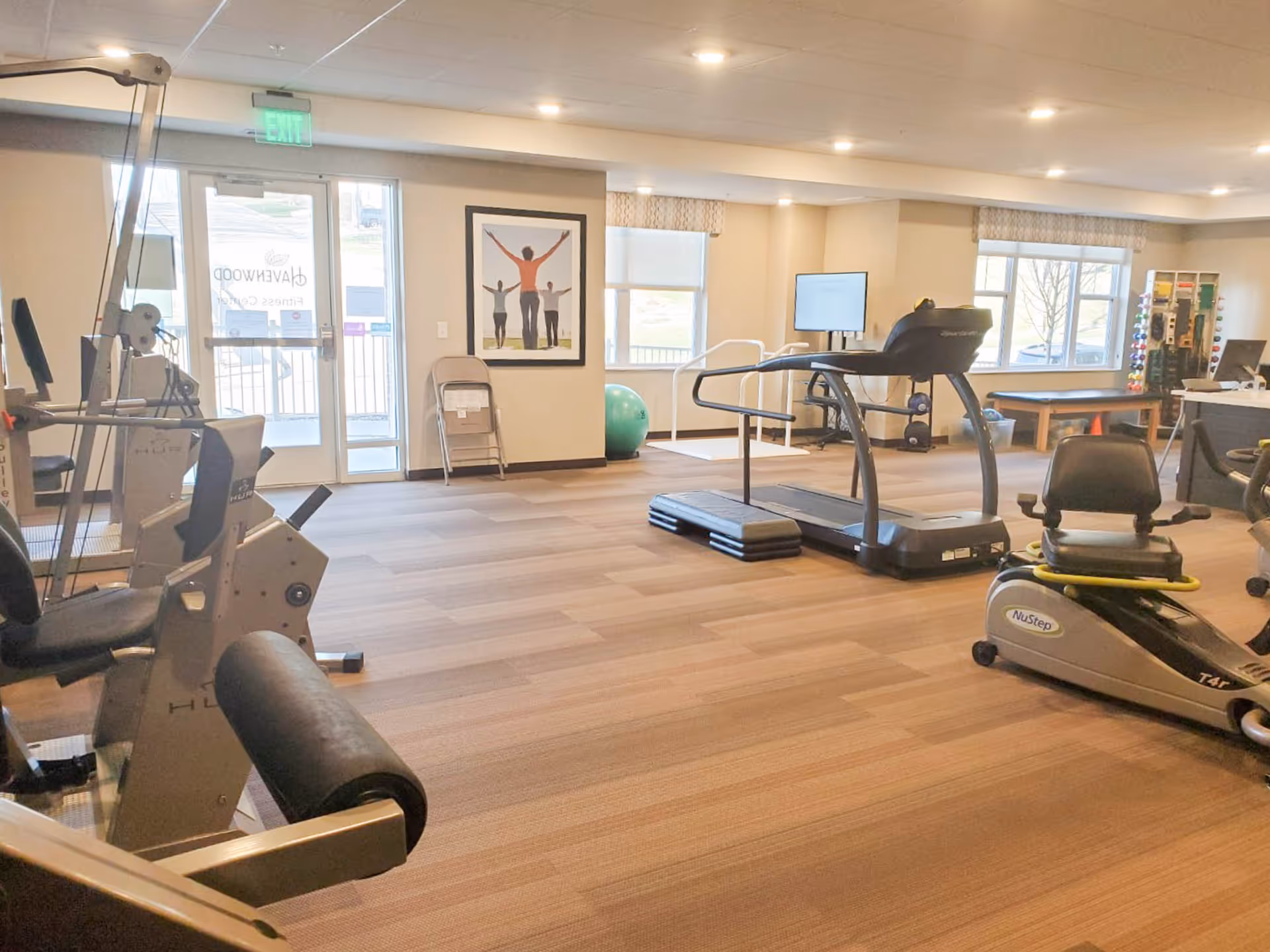 Bright fitness room with treadmills, weight machines, and a recumbent bike.