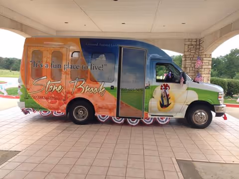 Colorful Stone Brook Assisted Living van parked under a covered entrance.