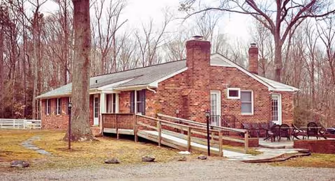 Brick single-story assisted living building with ramp, porch, and outdoor seating