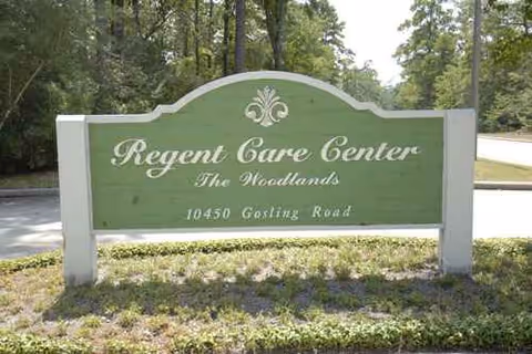 Regent Care Center The Woodlands sign on a grassy, tree-lined front area.