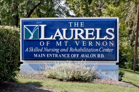 Blue sign reading The Laurels of Mt. Vernon with surrounding landscaping
