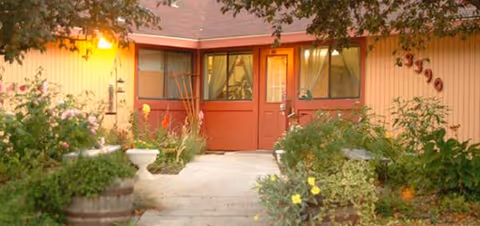 Front entrance of Cottage at Boise Samaritan Village with red doors and garden planters.
