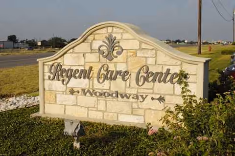 Outdoor stone sign reads Regent Care Center Woodway with surrounding landscaping.