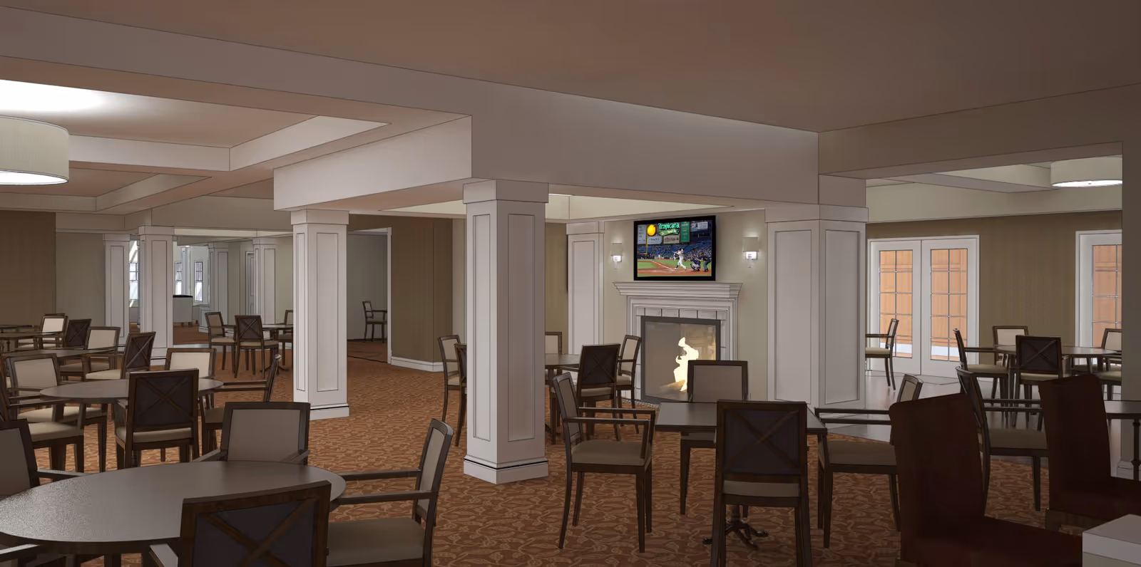 Interior view of a senior living facility common area with multiple round tables and chairs arranged on a patterned carpet. The room features white columns, a fireplace with a TV mounted above it showing a baseball game, and large windows with glass doors letting in natural light.