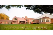 Front view of Crawford County Care Center, a brick facility with red roof and green lawn.
