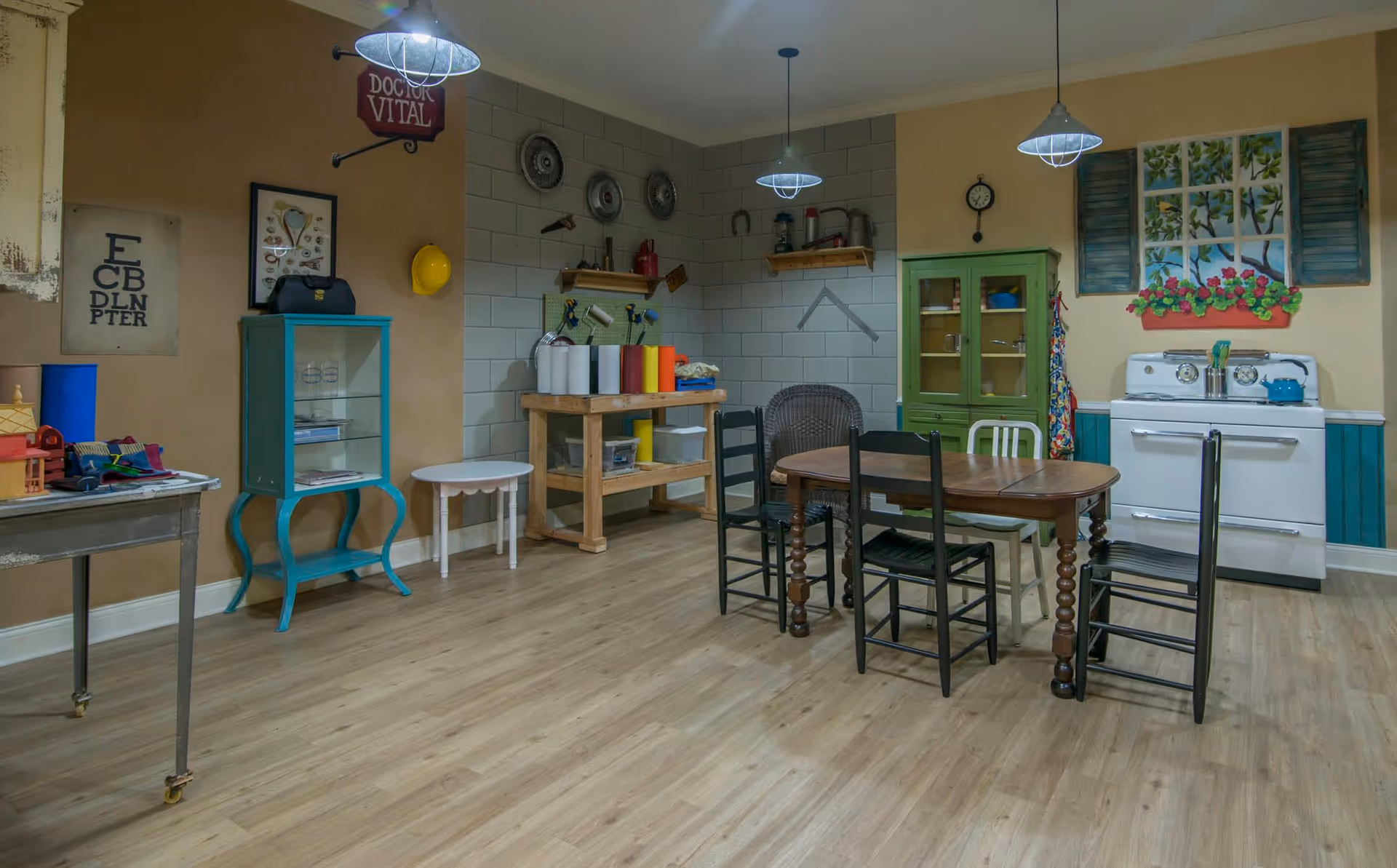 Communal dining and kitchen-style activity room with a wooden table and chairs, a vintage stove, cabinets, and decorative wall accents.