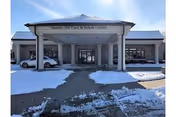 Exterior view of Sunrise Hill Care & Rehab Center entrance with snow-covered parking.