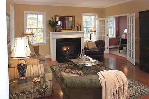 Cozy living room with a fireplace, seating, and glass coffee table.