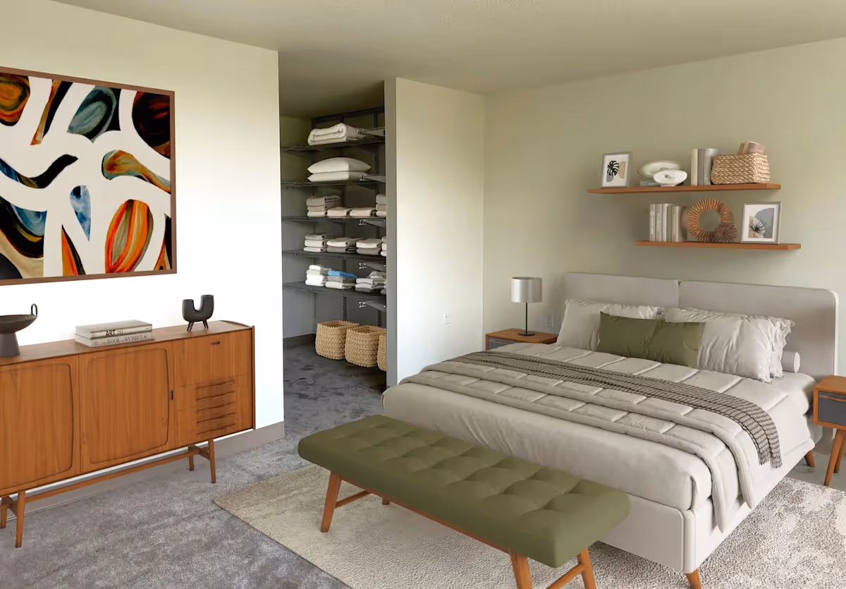 A neatly arranged bedroom in a senior living facility with a bed, bench at the foot, and an open closet with towels.