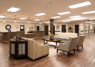 An interior view of a senior living facility featuring seating areas and reception.