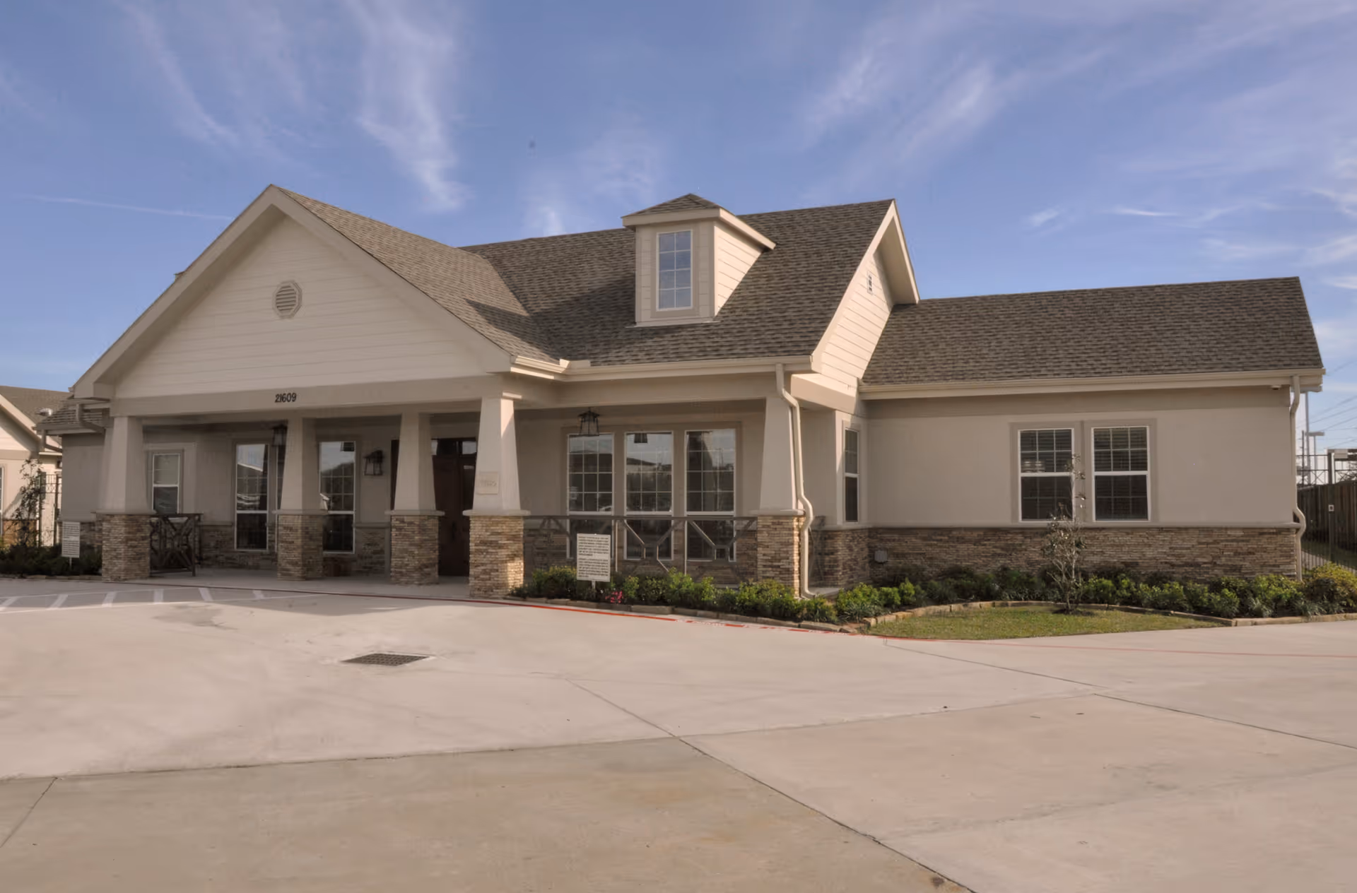 Front view of a single-story senior living facility with a covered entrance.