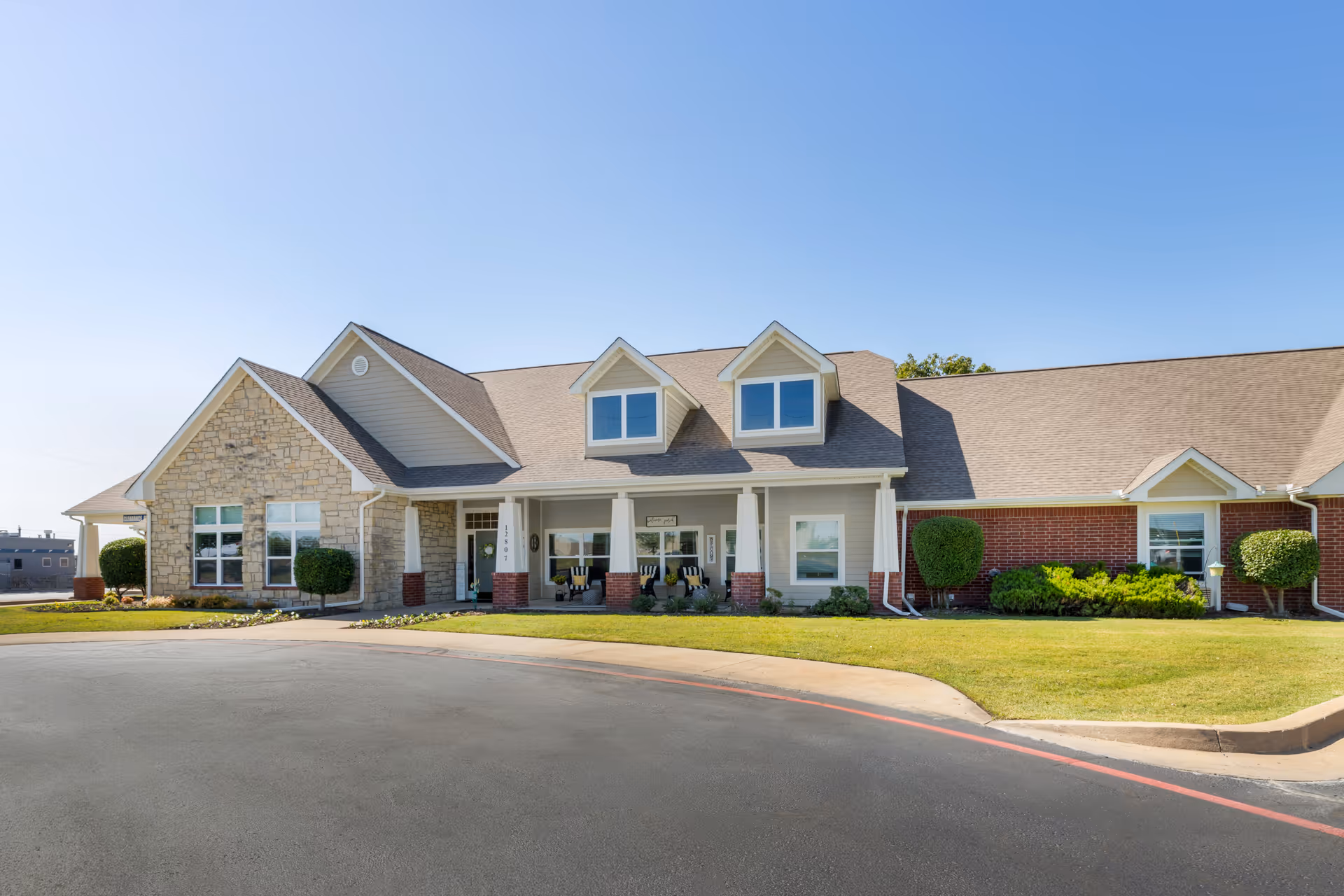 Front view of Brookdale Owasso senior living facility with entrance and landscaping.