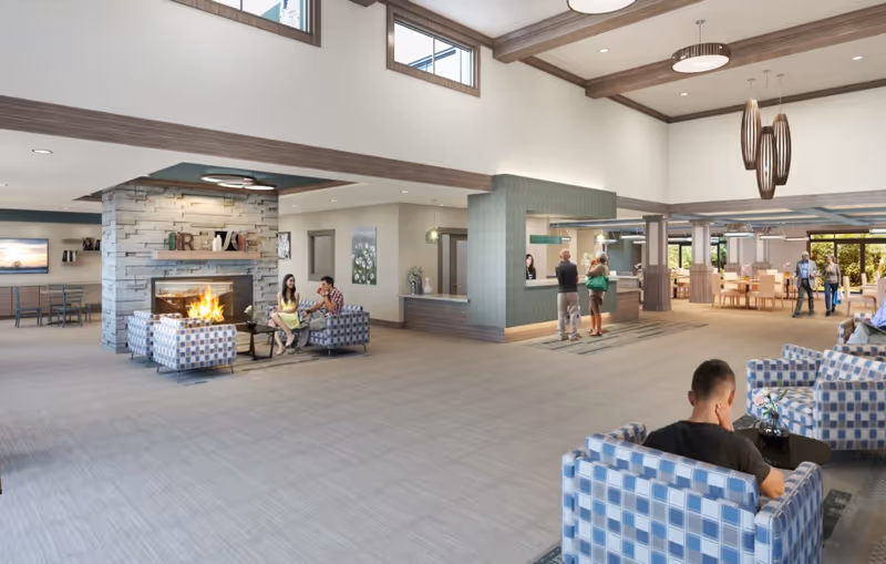 Spacious senior living lobby with fireplace, modern seating, and residents socializing.