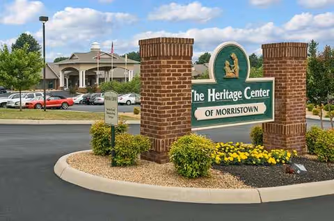 The Heritage Center of Morristown entrance sign with brick pillars, landscaping, and parking.