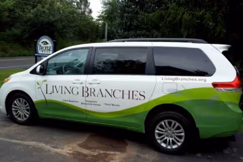 Living Branches van with green graphics parked outside Souderton Mennonite Homes.
