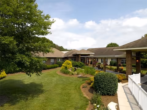 Exterior view of Knoxville Landing facility with landscaped lawn and walkway leading to entrances.