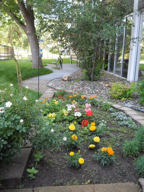 Colorful flowers line a walkway by the facility's outdoor garden.