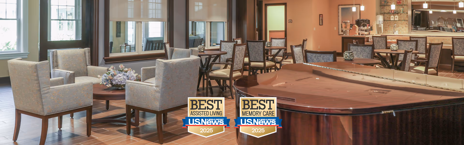 Spacious senior living common area with a grand piano, seating clusters, dining tables and a service counter.