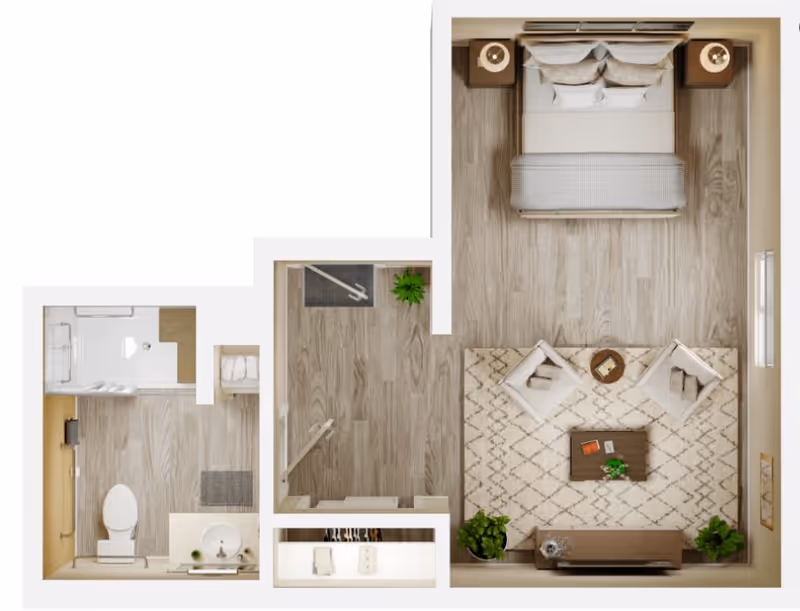 Top-down view of a senior living facility apartment floor plan showing a bedroom with a bed, two nightstands with lamps, two armchairs with a small round table between them on a patterned rug, a TV stand with a TV, and two plants. Adjacent to the bedroom is a bathroom with a toilet, sink, and shower, and a small closet area with hanging clothes and shelves.