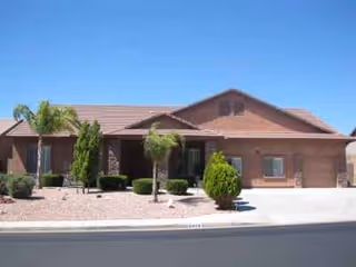 One-story brick assisted living home with desert landscaping and a broad front entrance.