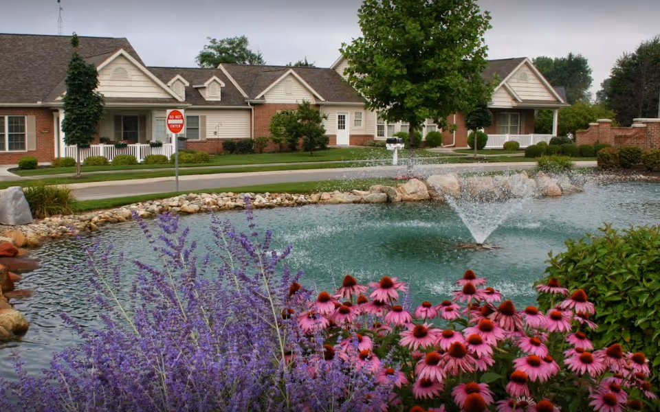 Greencroft Middlebury senior living campus with pond fountain and flowering plants