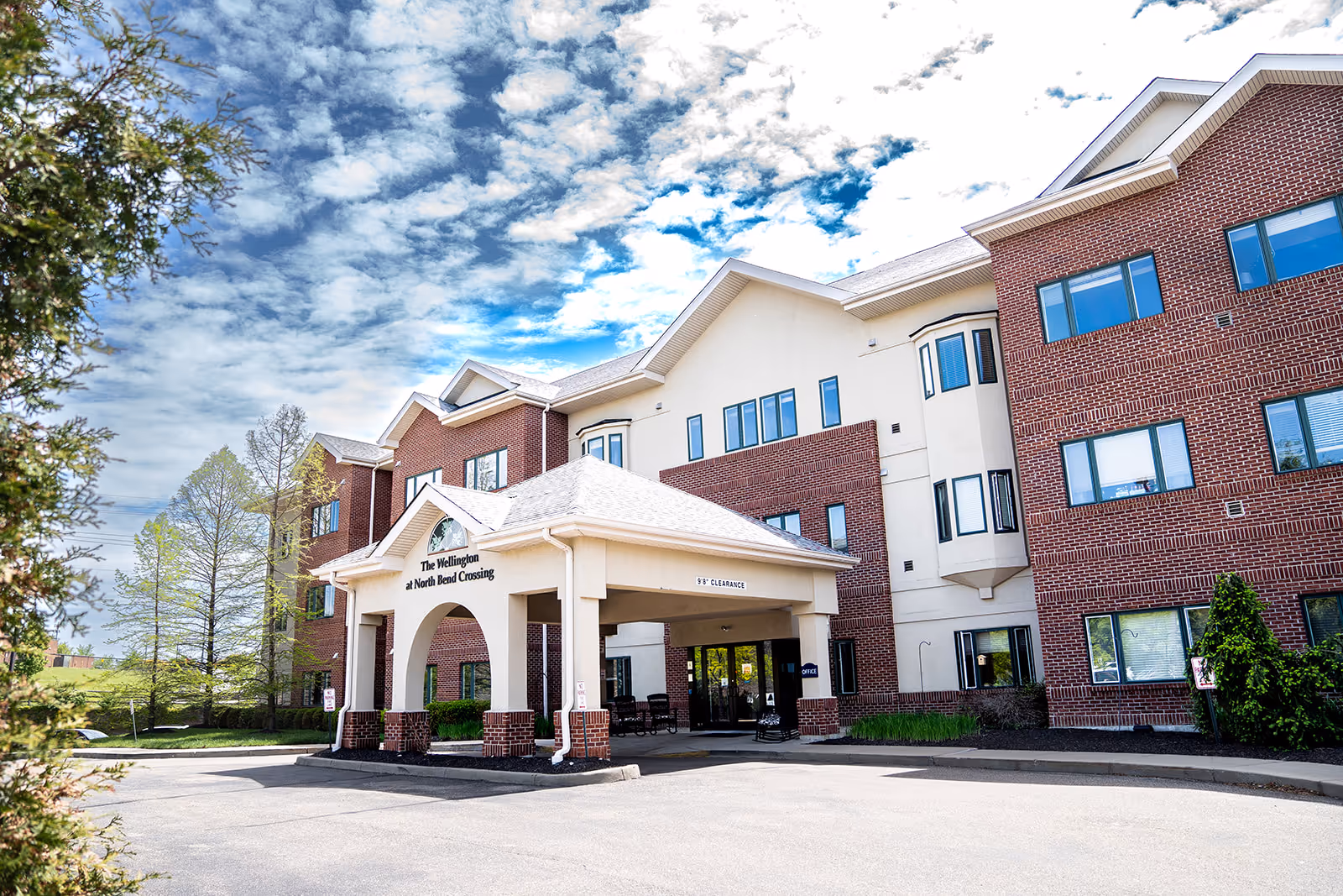 Exterior view of The Wellington at North Bend Crossing entrance and brick building.