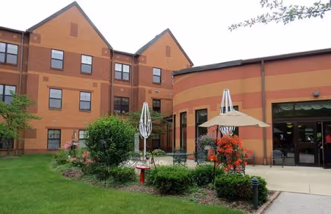 Exterior of Lutheran Village at Wolf Creek with patio seating and landscaped lawn.