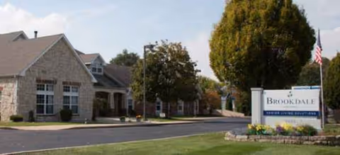 Exterior view of Kokomo Place facility with Brookdale sign and landscaped front entrance.