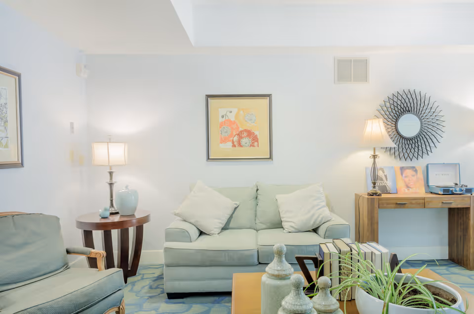 Cozy living room in light blue tones with sofa, chairs, and decorative accents.