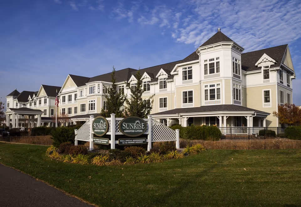 A large, multi-story Sunrise assisted living building with a landscaped front lawn.