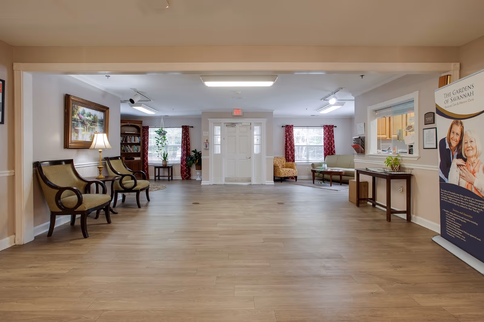 Spacious lobby-style common area with chairs, sofas, side tables, and a reception window.