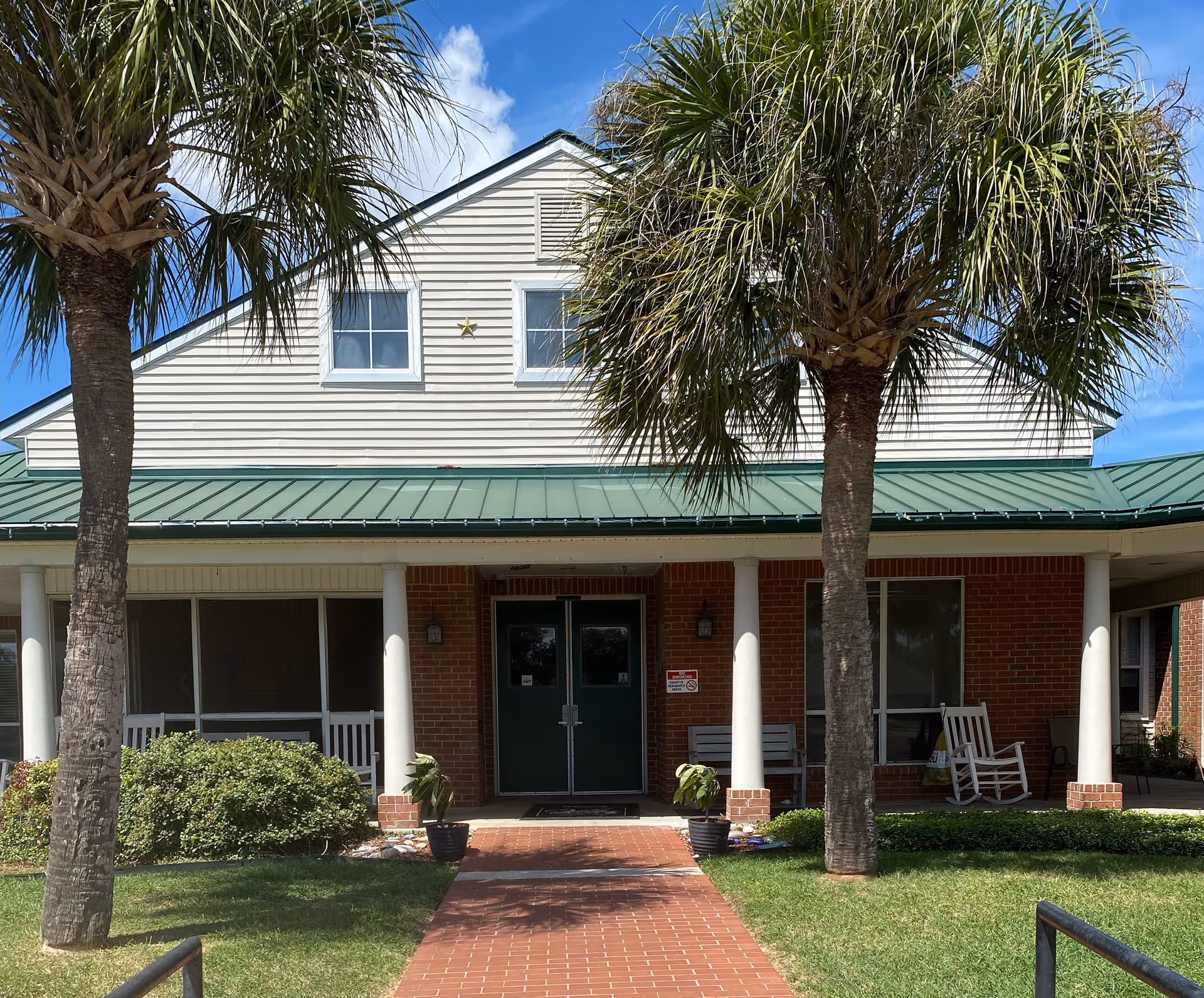 Front view of Villa of Corpus Christi South with palm trees and entrance.