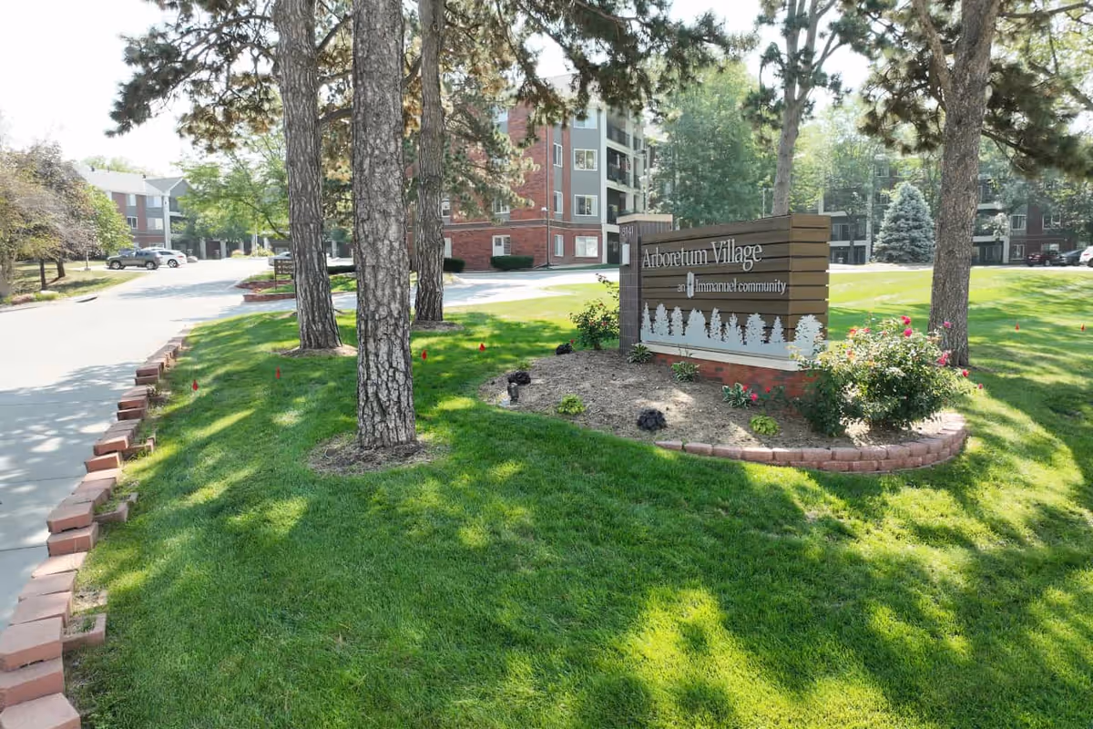 Exterior view of Arboretum Village with a landscaped lawn and front sign.