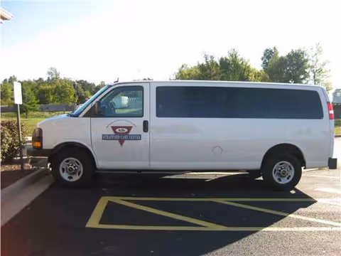 White Strafford Care Center van parked in a lot beside greenery