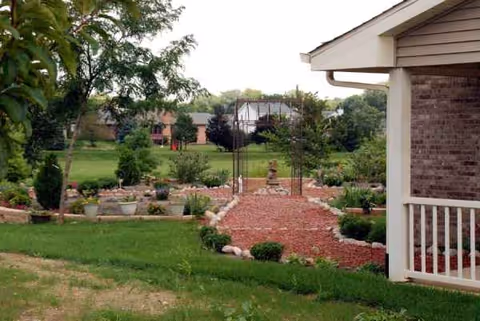 Outdoor landscaped garden with a brick path beside the facility building