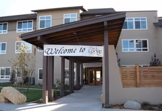 Two-story senior living building with a covered entrance and The Lodge sign